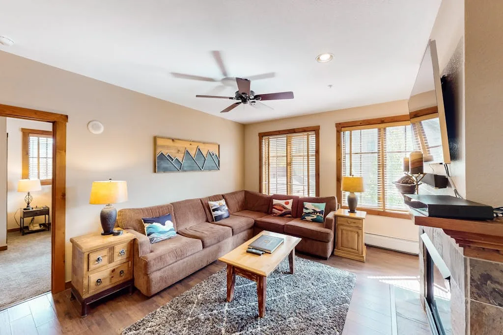 Living room with sectional seating, a coffee table, and large windows.