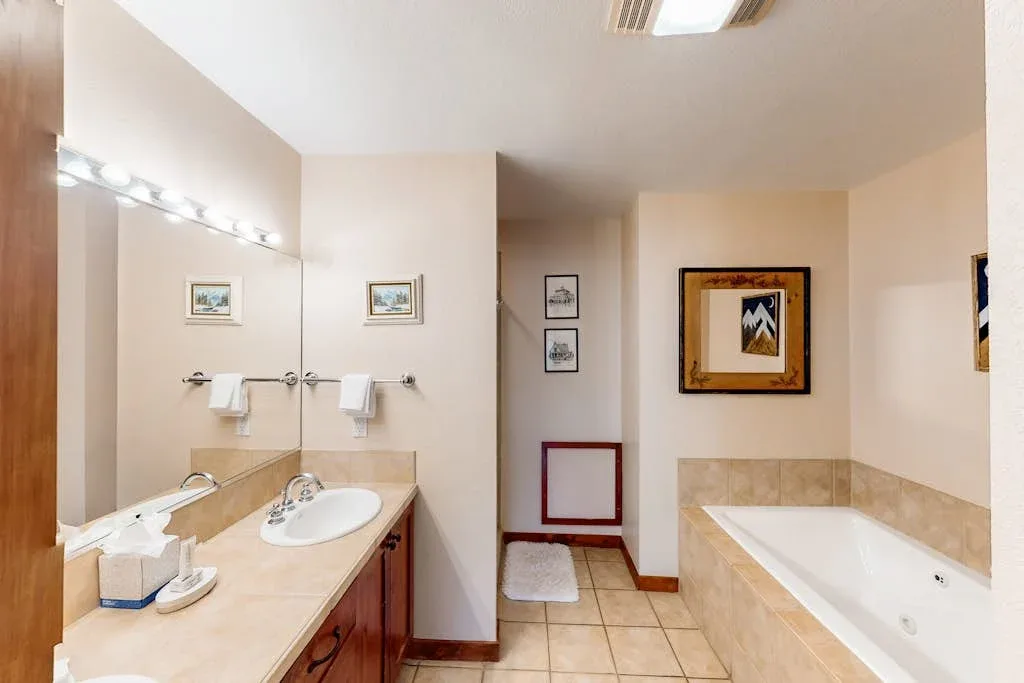 A bathroom with a long sink counter and a bathtub along the opposite wall.