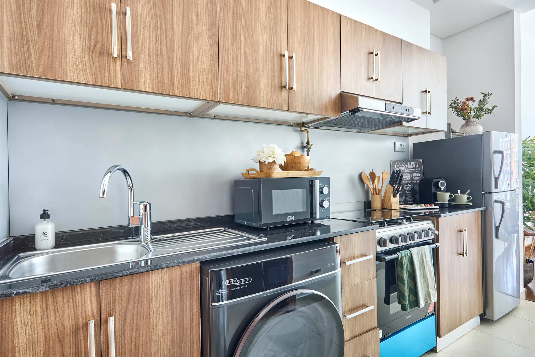 A modern kitchen with wood cabinets, a countertop, and stainless steel appliances.
