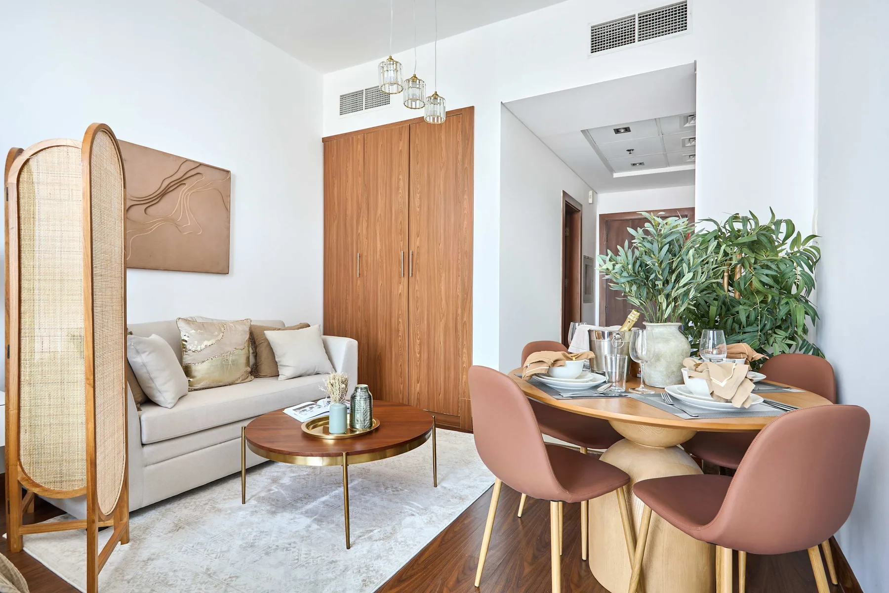 A bright living and dining area with a sofa and a set dining table.