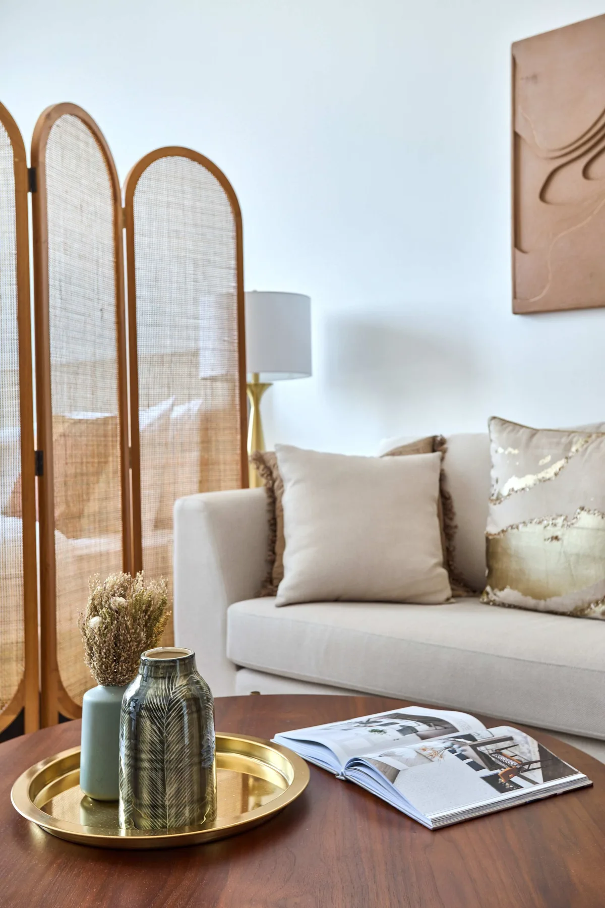 A bright living room with a light-colored sofa and a wooden coffee table.