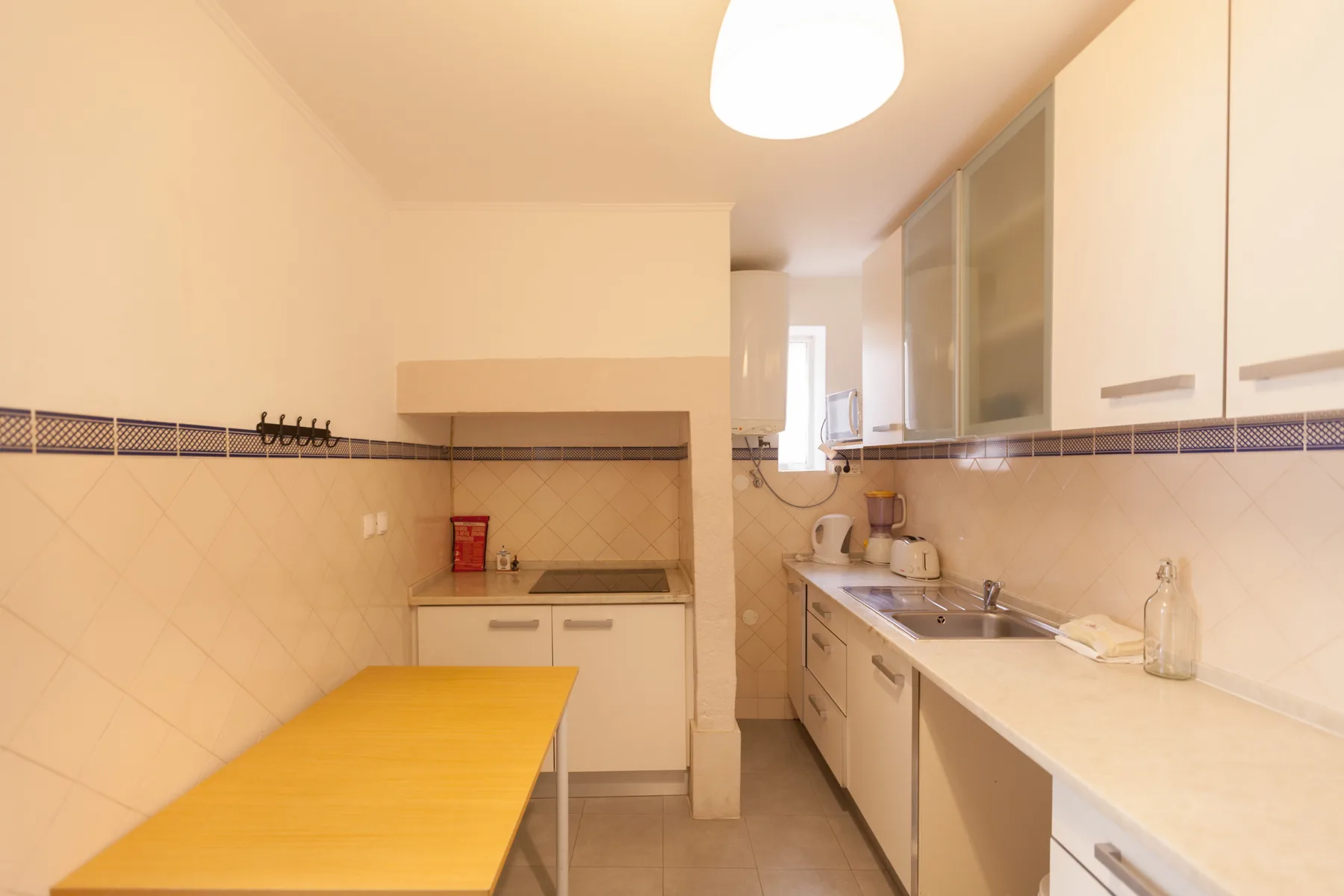 Una cocina luminosa con encimeras y una mesa.