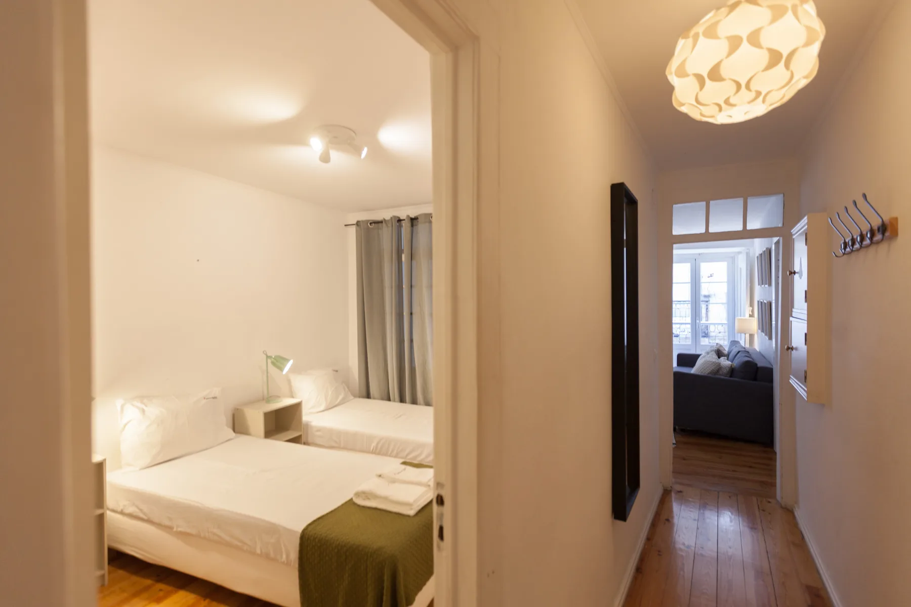 Un dormitorio con una cama da a un pasillo estrecho.
