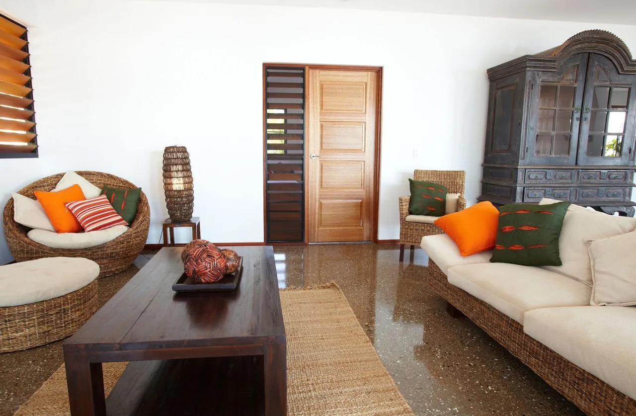 A living room with woven seating, a wooden coffee table, and a tall cabinet.