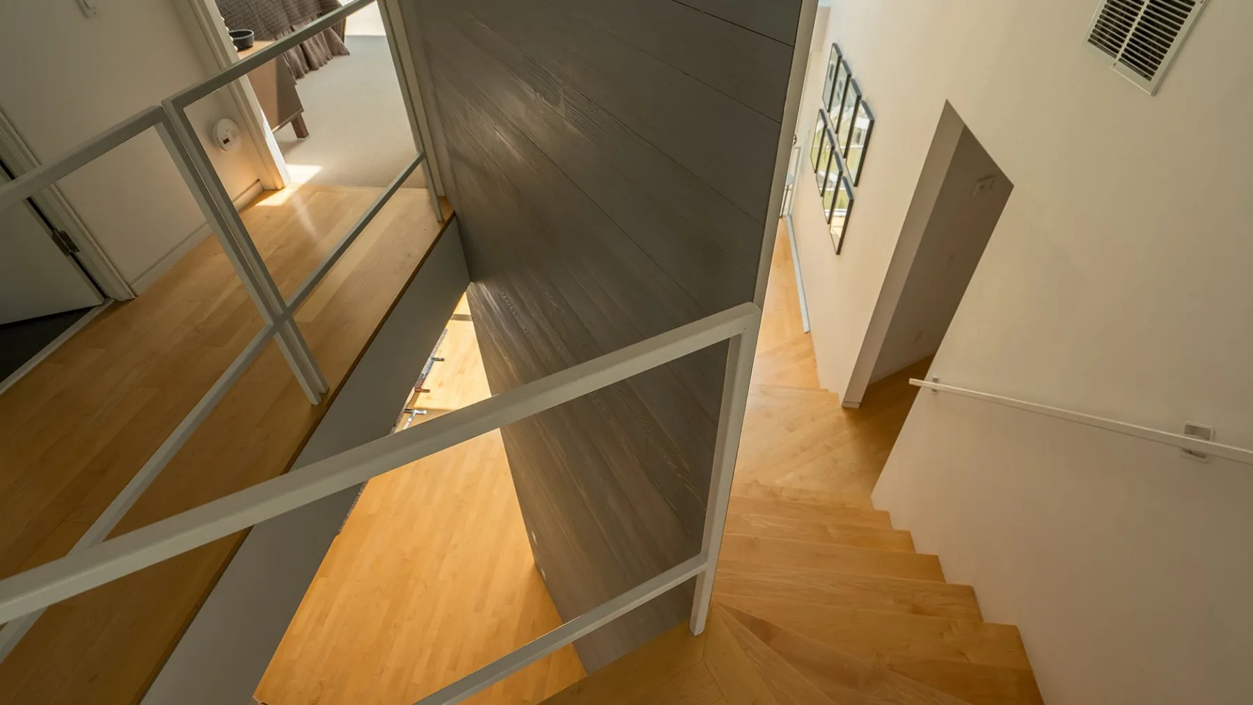 An interior staircase with wooden steps and a metal railing.