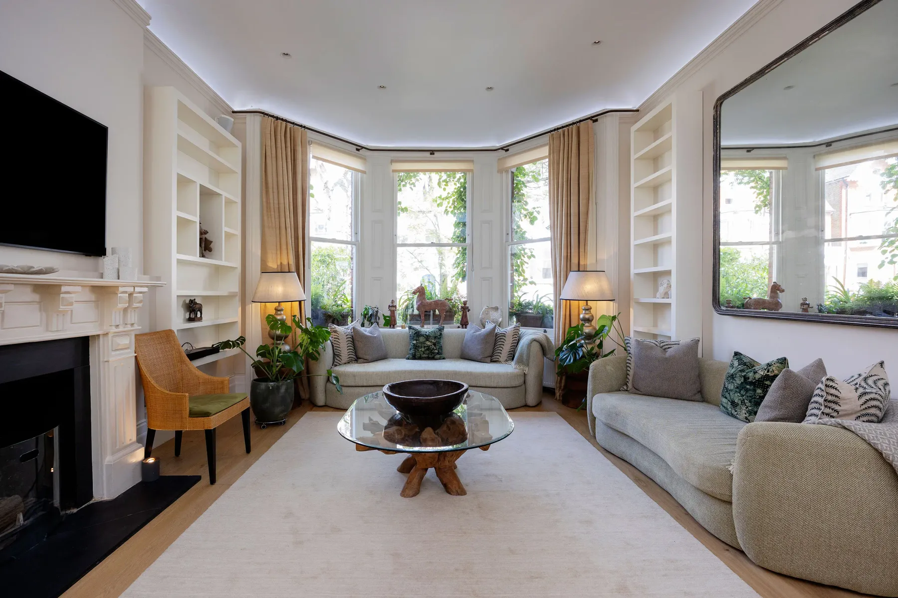 A bright living room with seating around a glass coffee table.