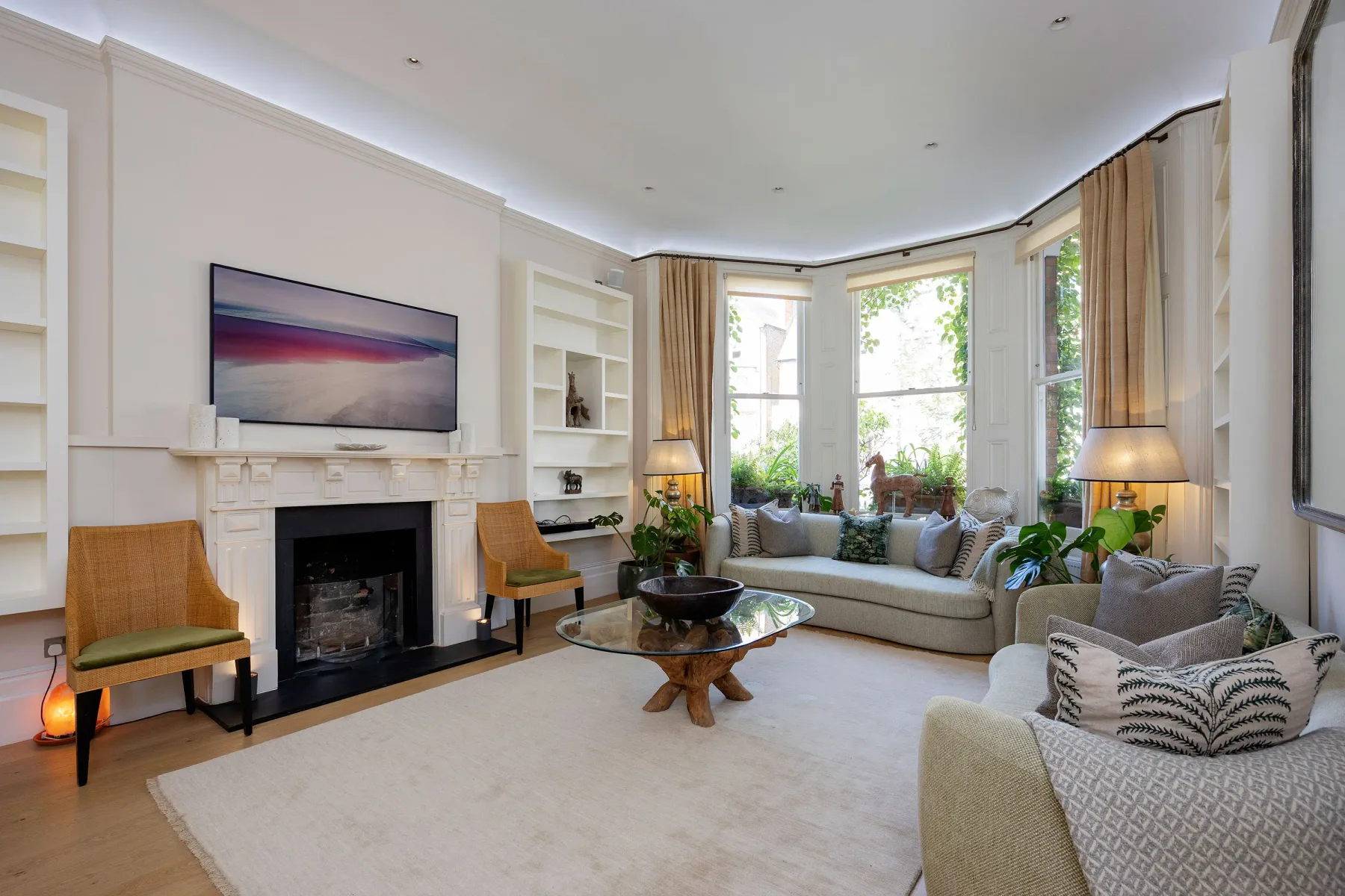 A bright living room with seating arranged around a fireplace and coffee table.