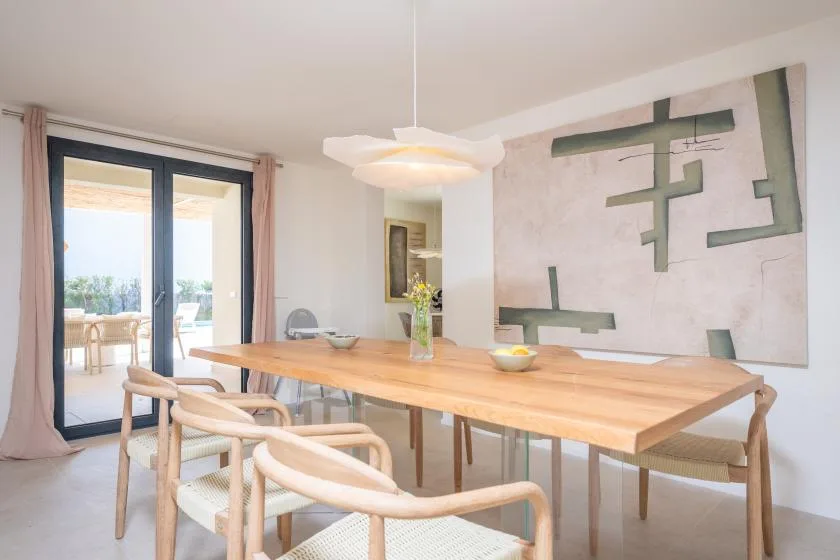 Comedor con una mesa larga de madera y puertas correderas de cristal.