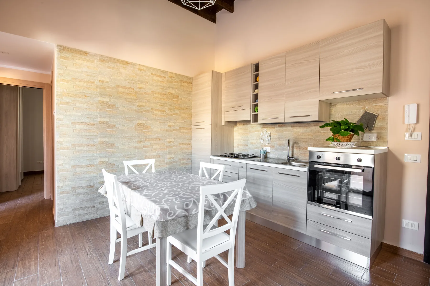 Comedor junto a una cocina equipada, con mesa y sillas.