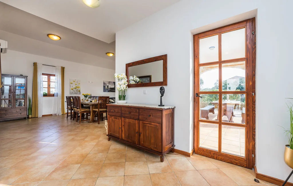 A dining area with a wooden table and cabinet beside glass doors.