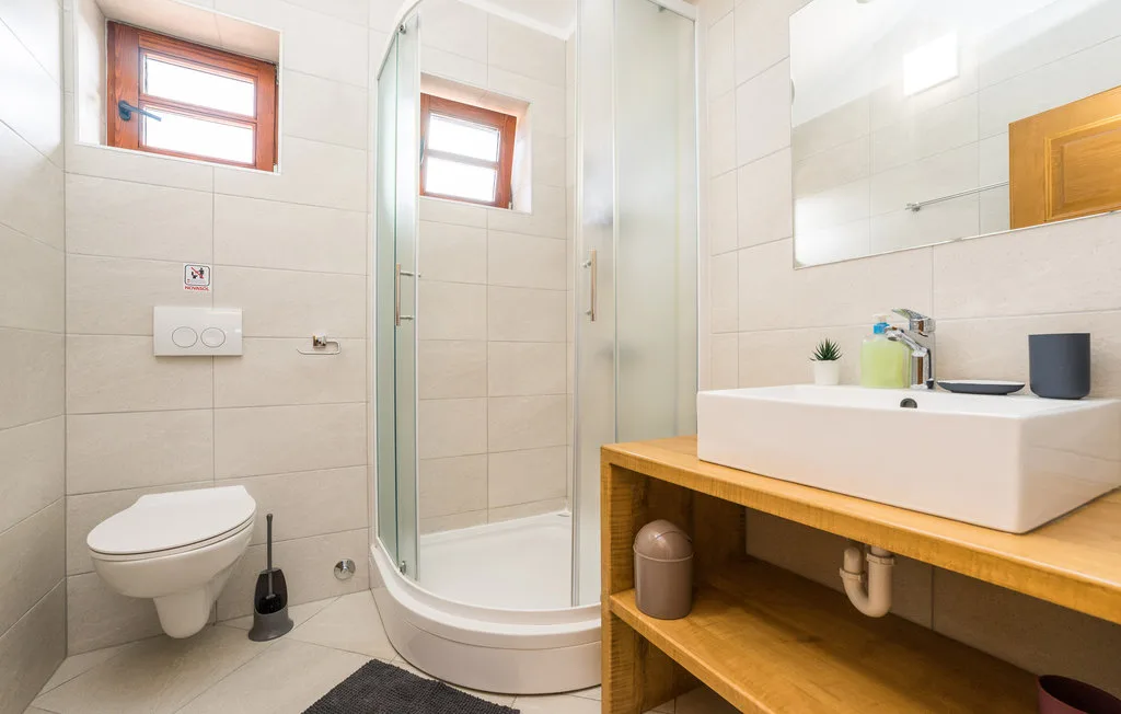 A bright bathroom with a shower, toilet, and sink.