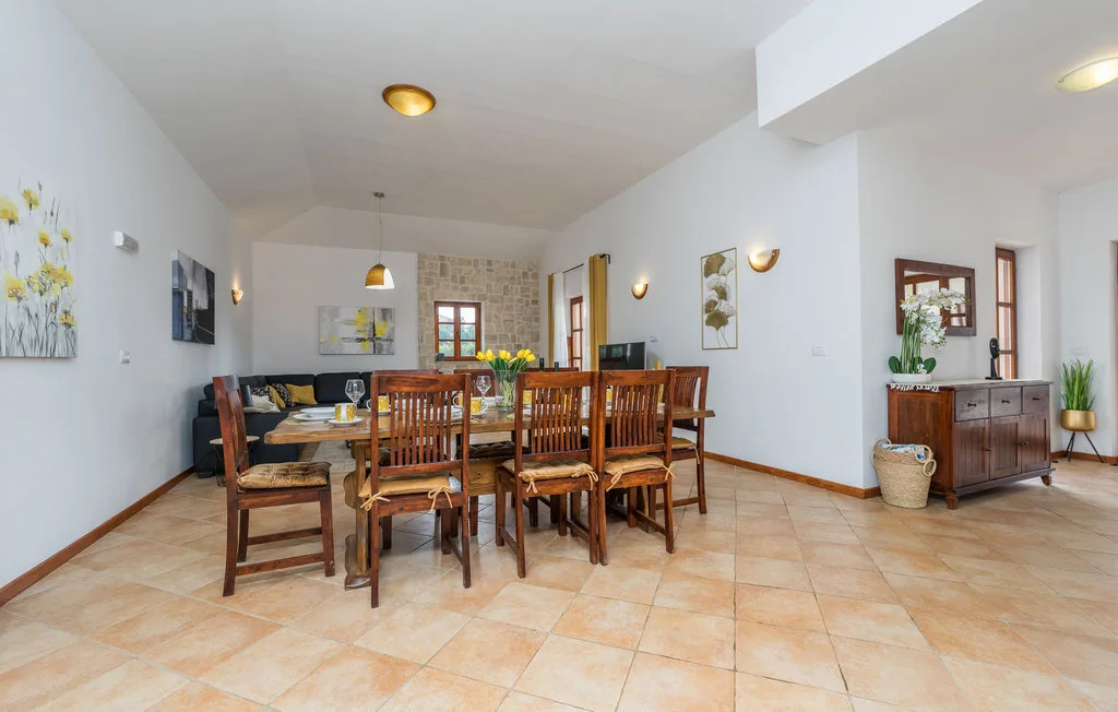 A dining area with a wooden table and chairs beside a living room.