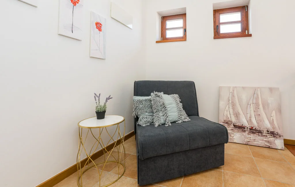 A bright sitting area with dark seating, decorative pillows, and framed artwork.