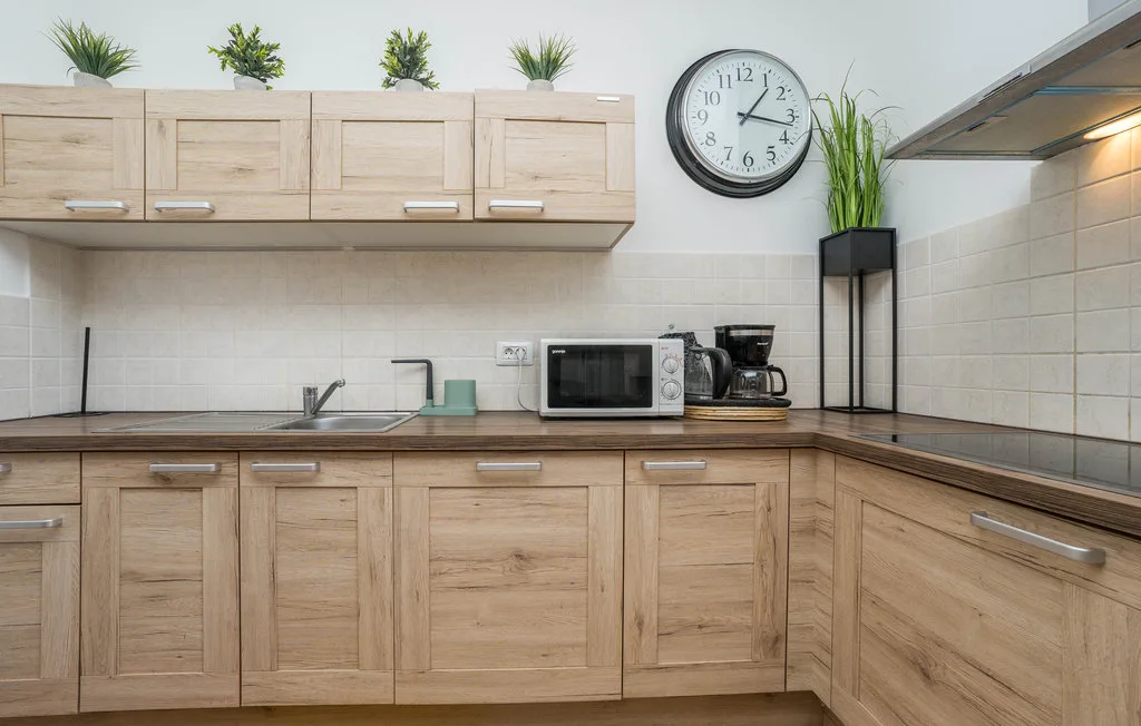 A kitchen with wooden cabinets, a countertop, and small appliances.