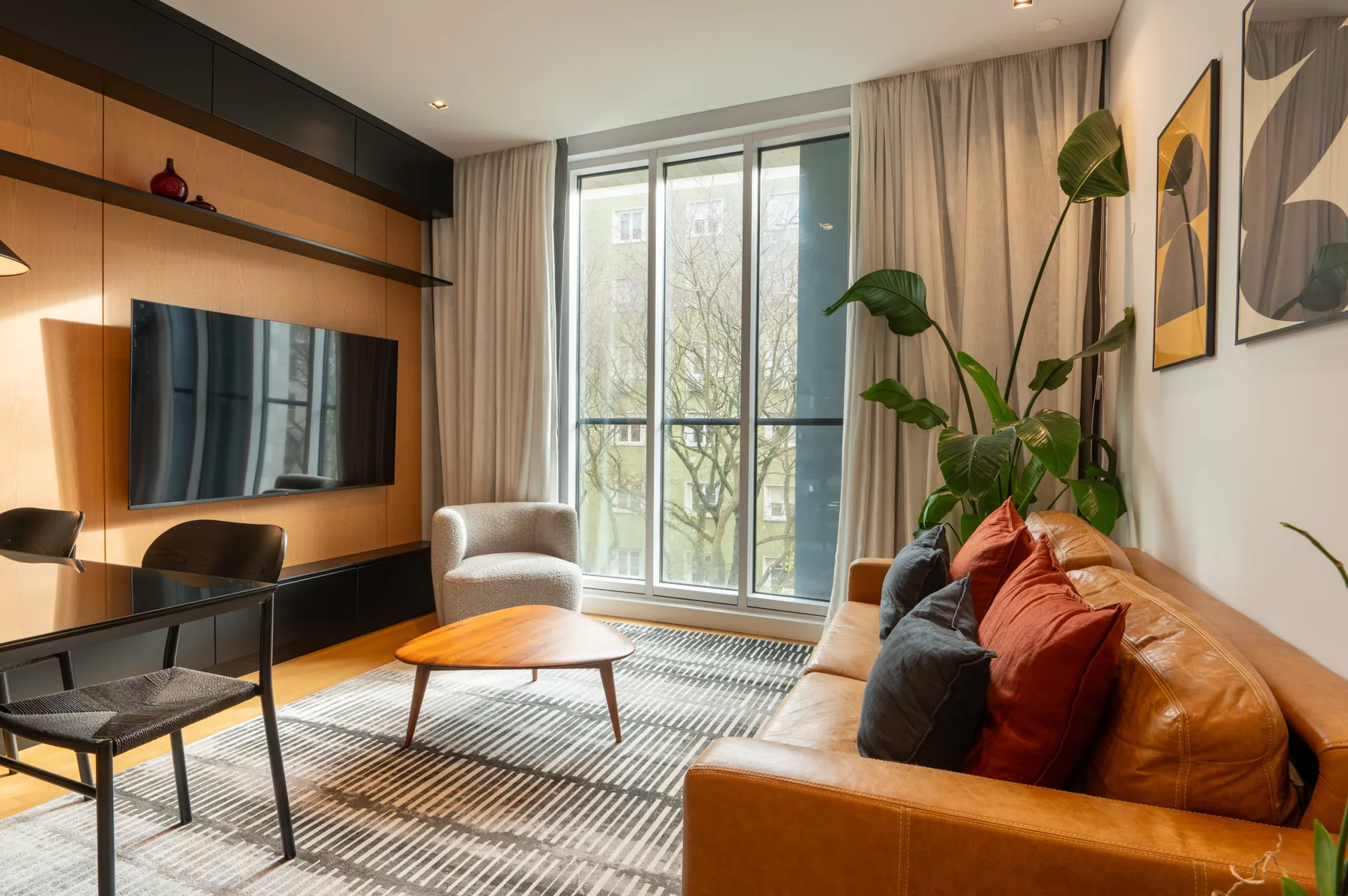 Living room with a seating area, coffee table, and large windows.