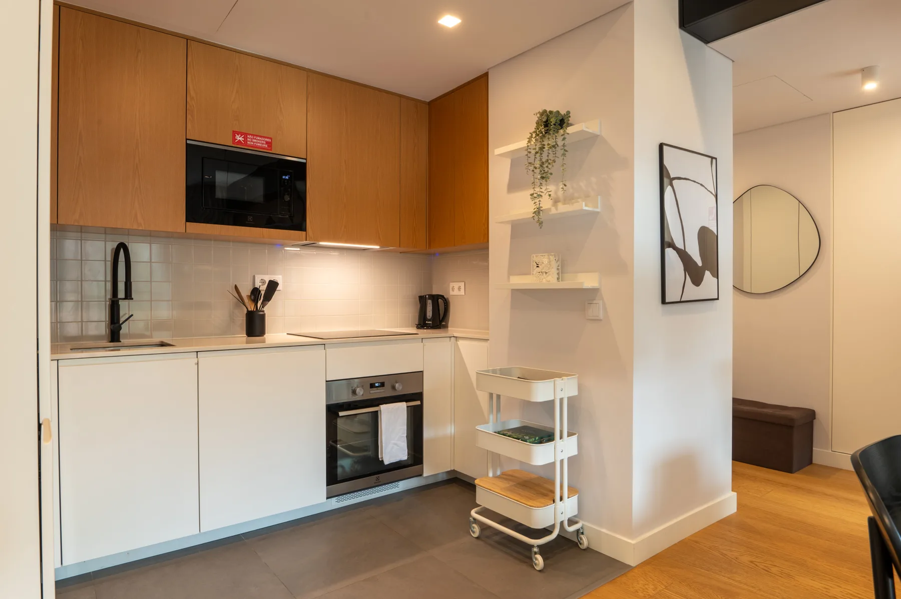 A modern kitchen with wood cabinets, white counters, and built-in appliances.