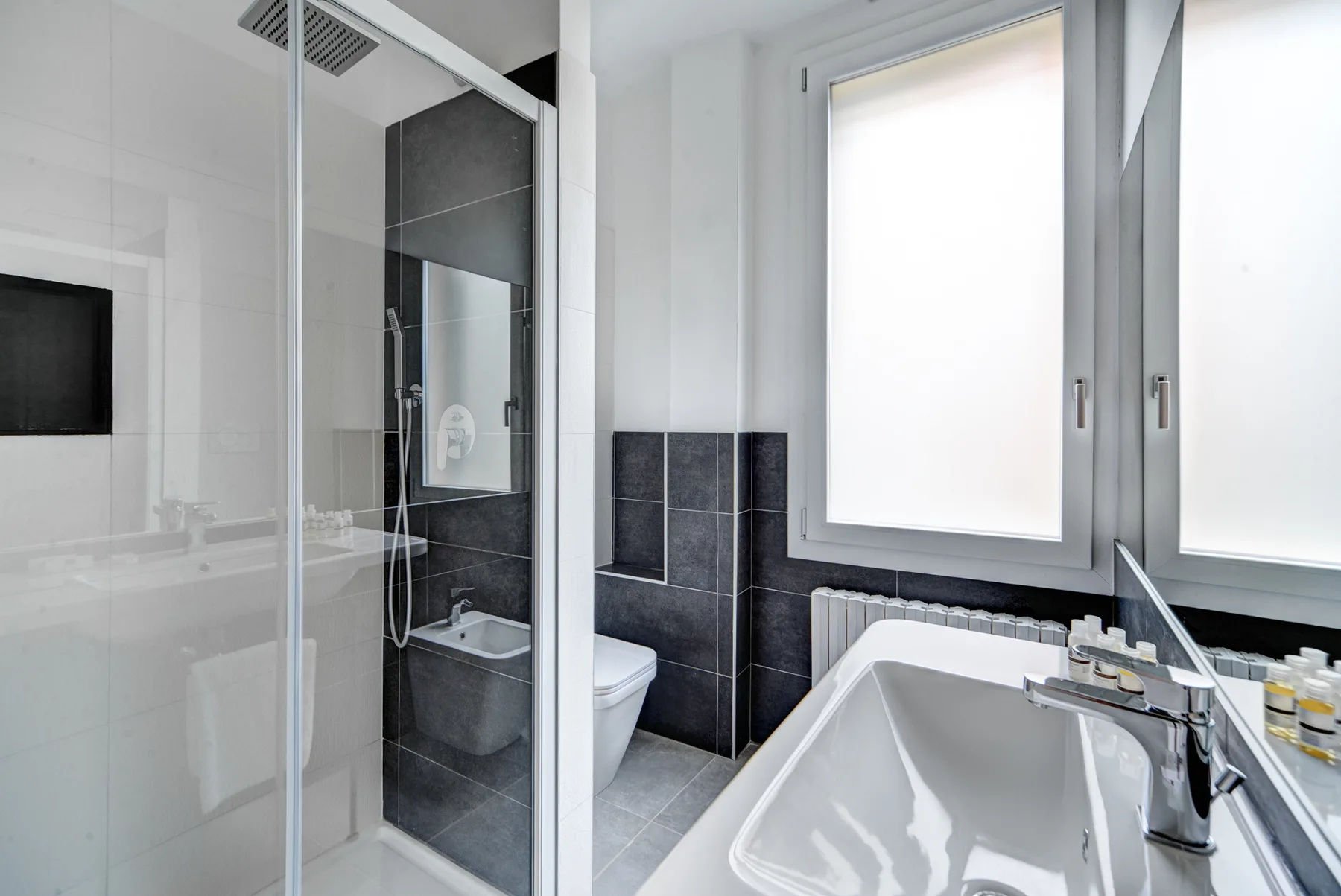 Un baño luminoso con bañera, ducha de vidrio y ventana.