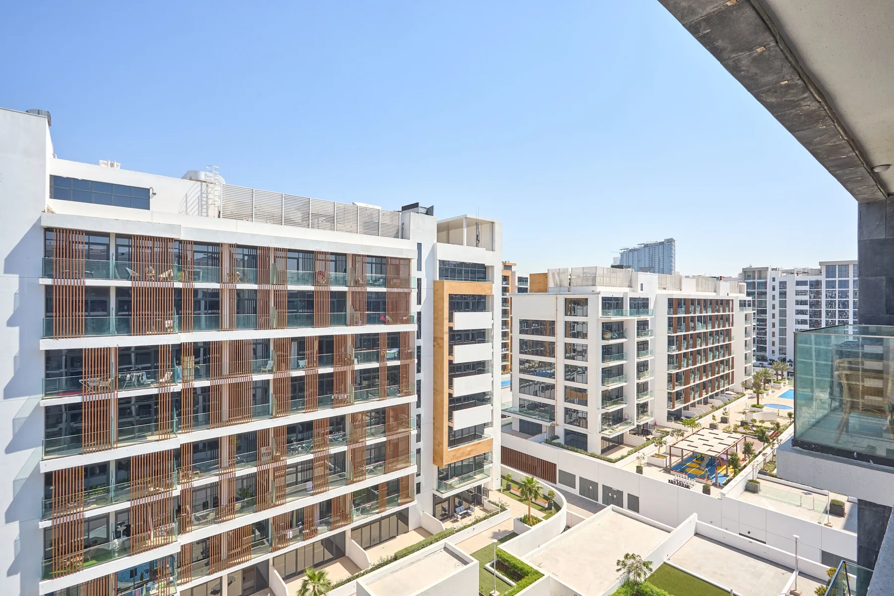 Edificios de apartamentos modernos rodean un patio exterior con una piscina.