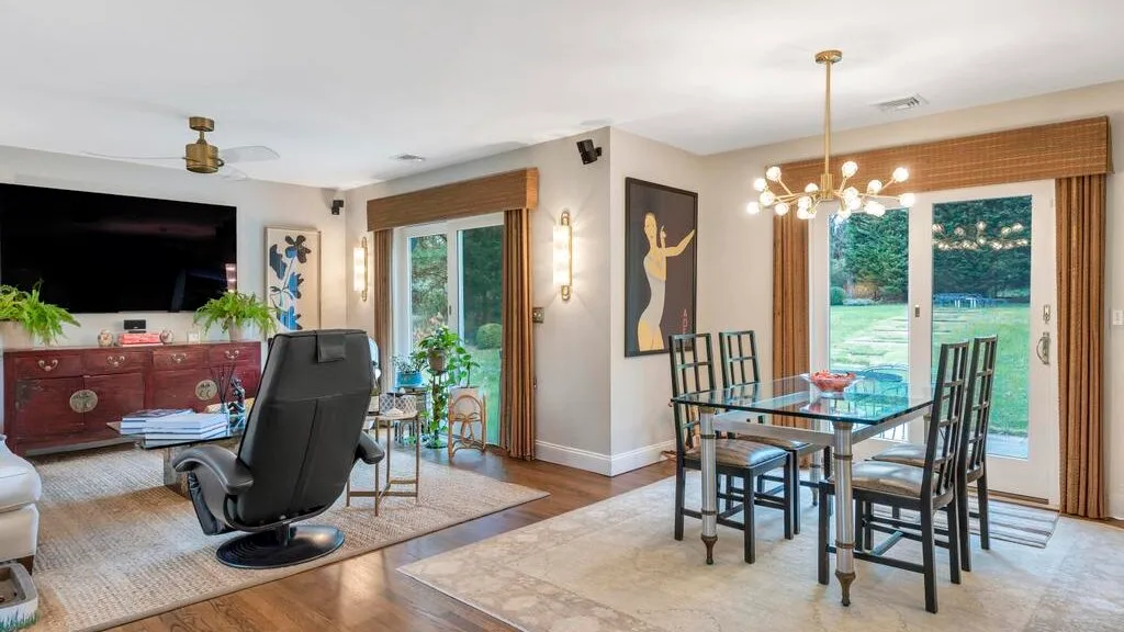 A bright living and dining area with glass doors opening onto a garden.