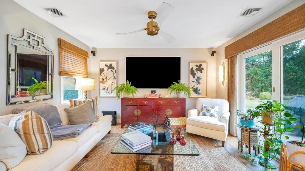 A bright living room with seating, a coffee table, and large windows.
