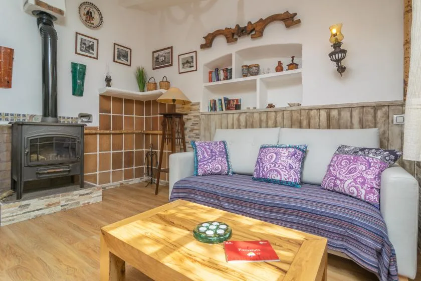 A living room with a wood stove, seating, and a wooden coffee table.