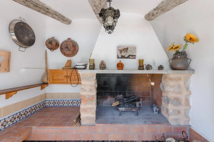 A rustic fireplace with a tiled hearth and decorative objects on the mantel.