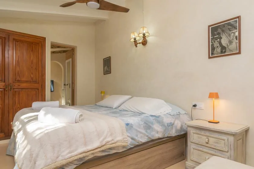 A bedroom with two beds and a bedside table.