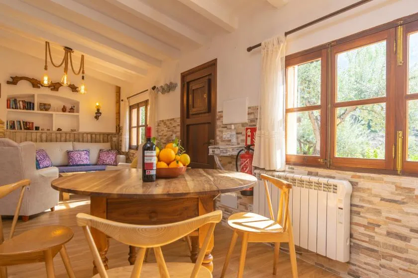 A dining area with a round table beside a large window.