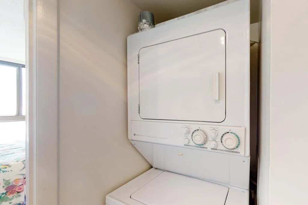 A stacked laundry appliance is installed in a small laundry nook.
