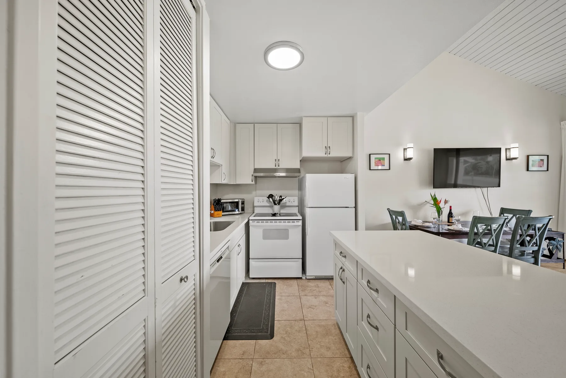 A bright kitchen with a long island opens onto a dining area.