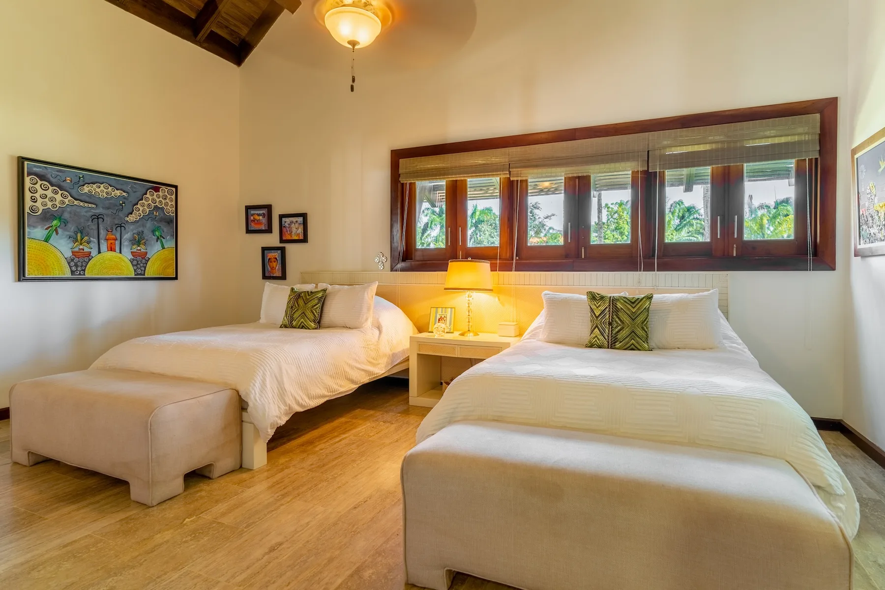 A bedroom with two beds beneath a row of windows.