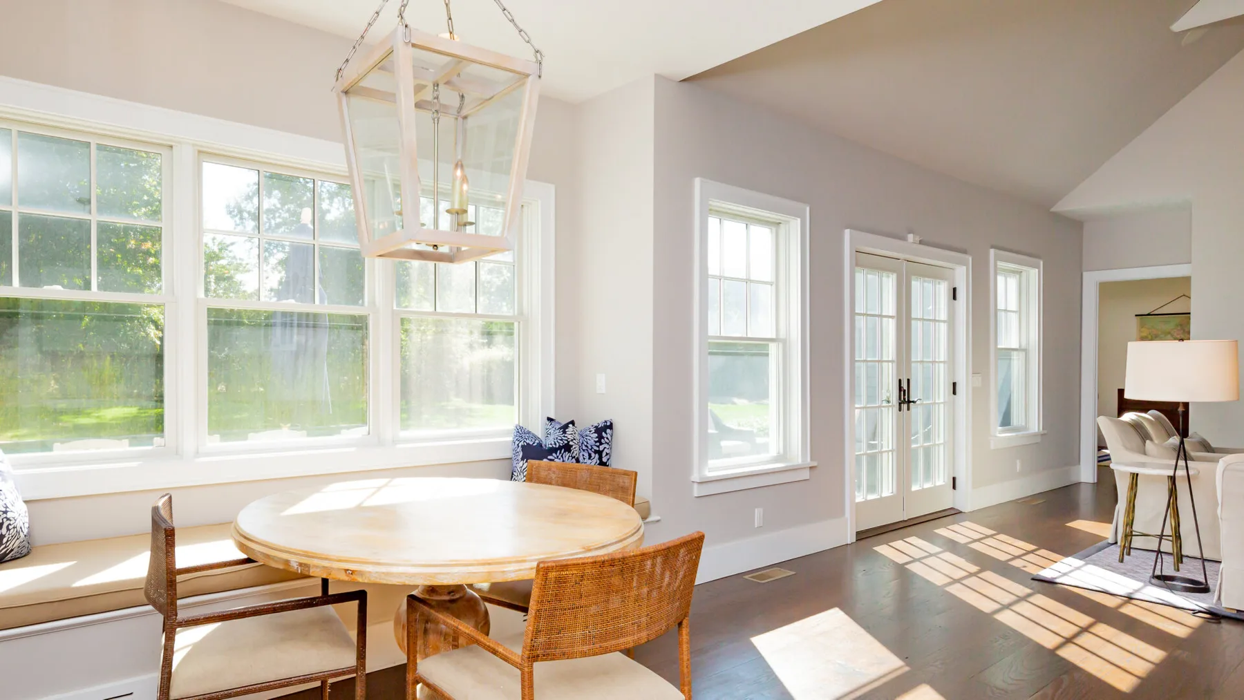 A bright dining area with a round table beside large windows.