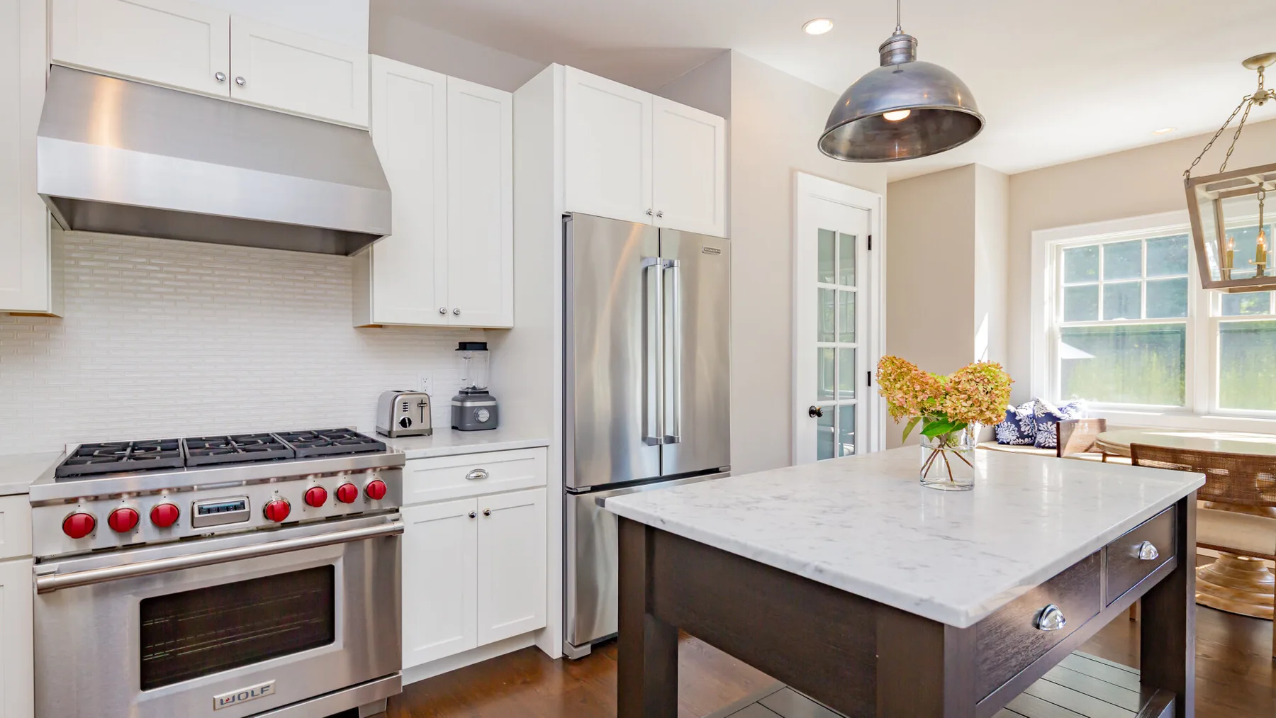 A bright kitchen with white cabinets and a large central island.