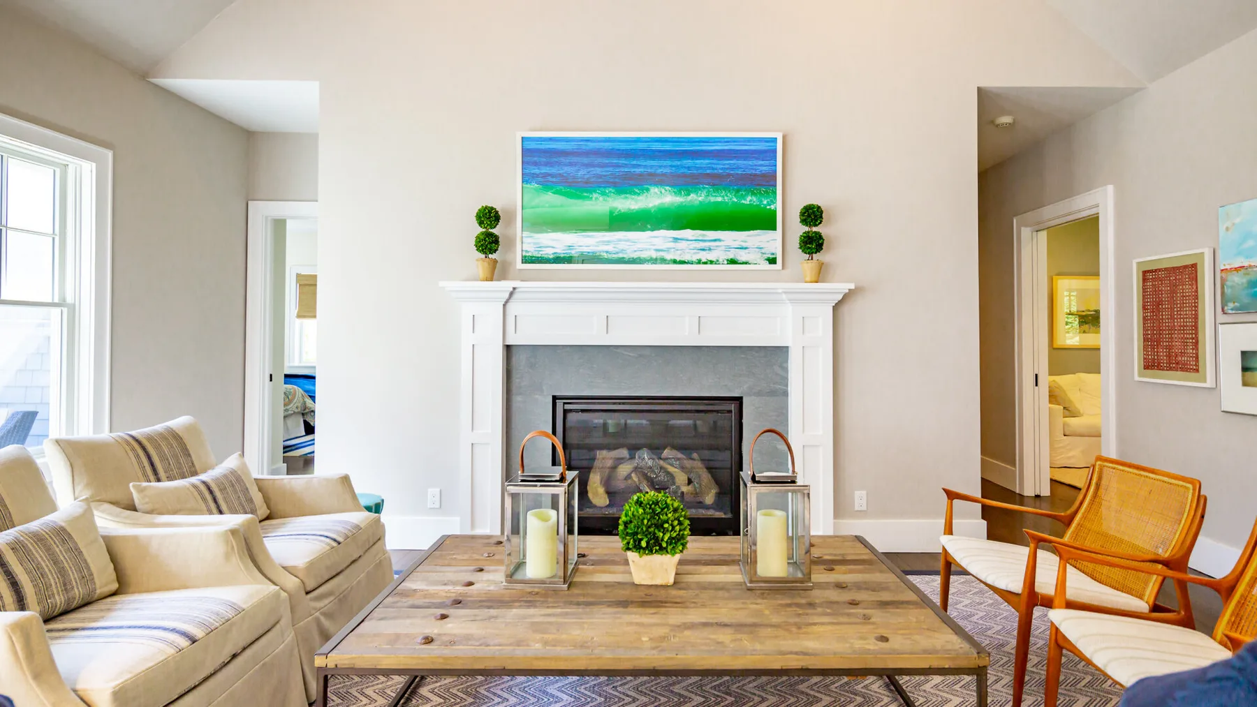 A bright living room with a fireplace, seating, and a wooden coffee table.