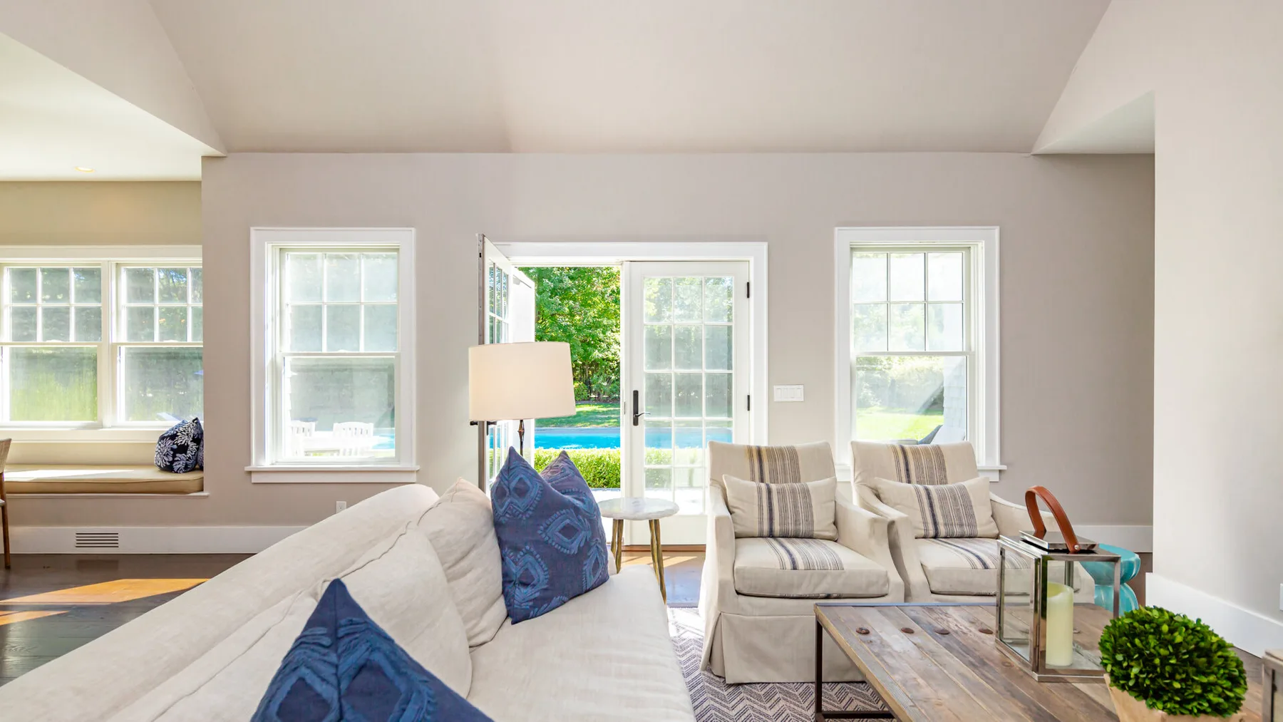 A bright living room with seating arranged around a low coffee table.