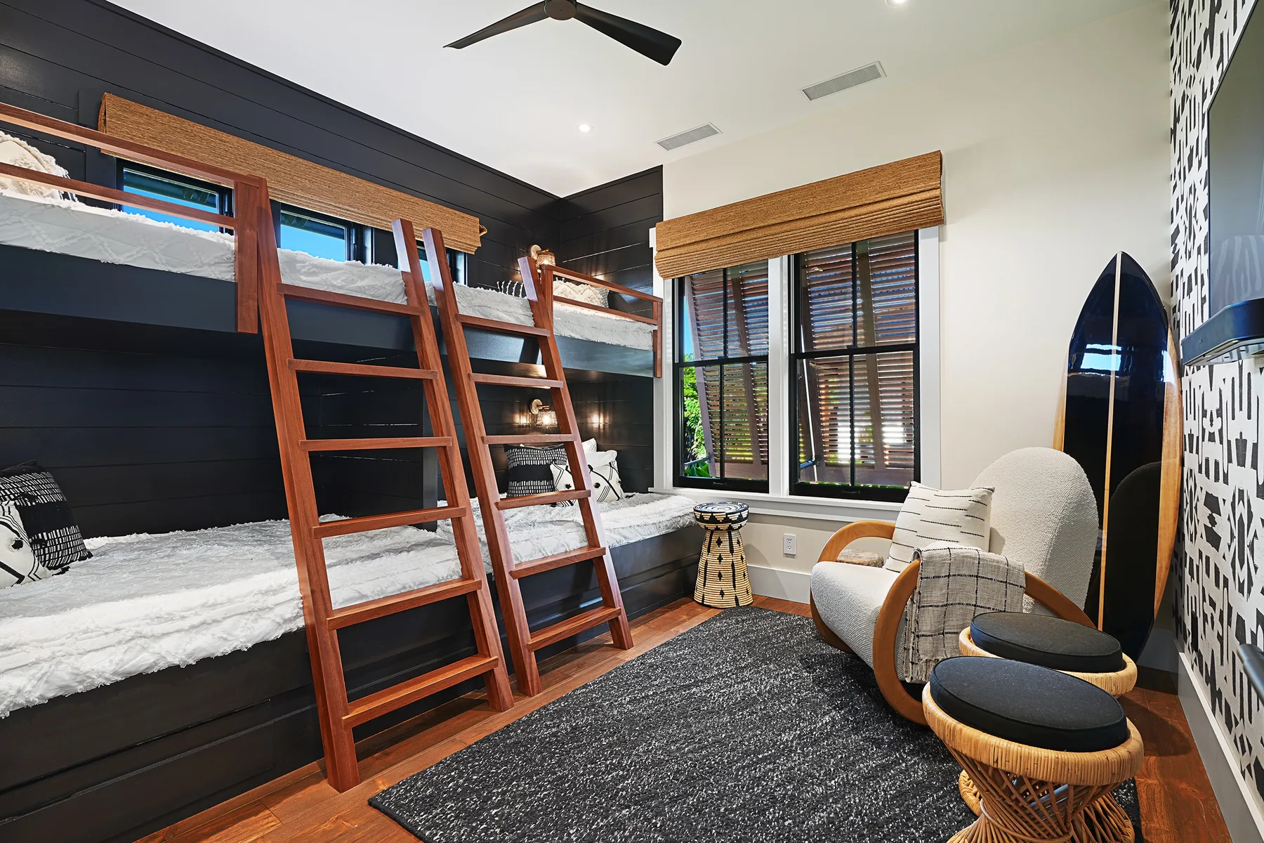 A bedroom with two wooden bunk beds, a window, and a seating area.