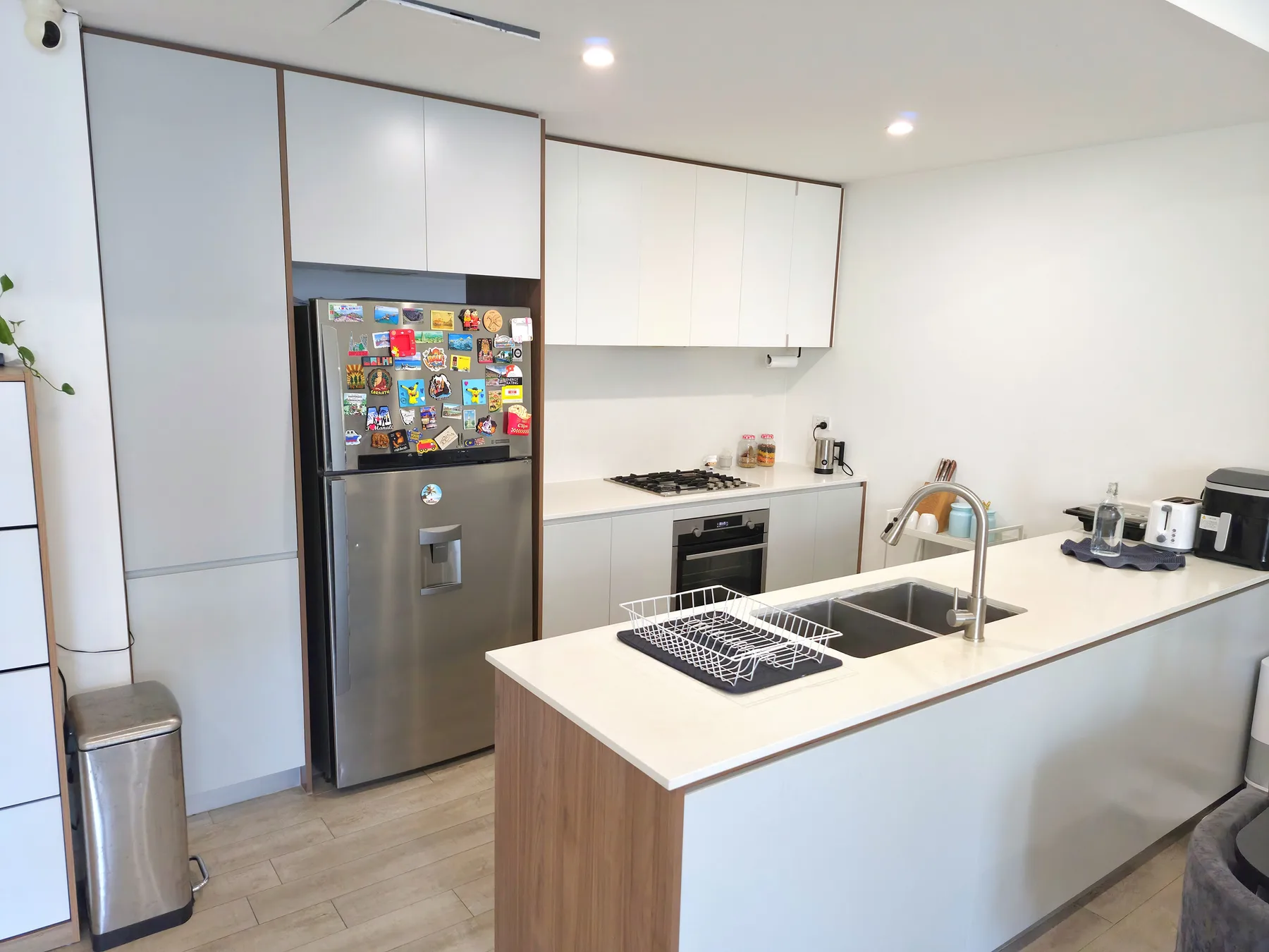 A modern kitchen with white cabinets, a refrigerator, and a central island.
