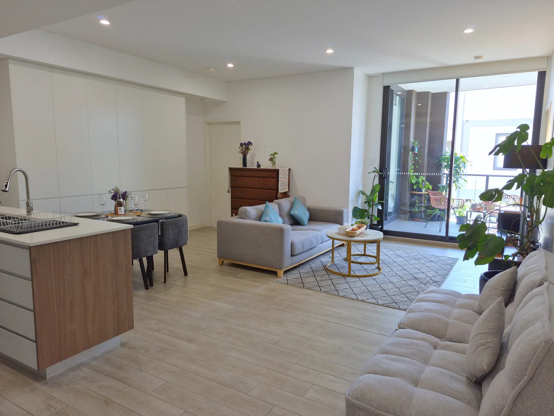 Open-plan living room with a kitchen island, seating, and large glass doors.