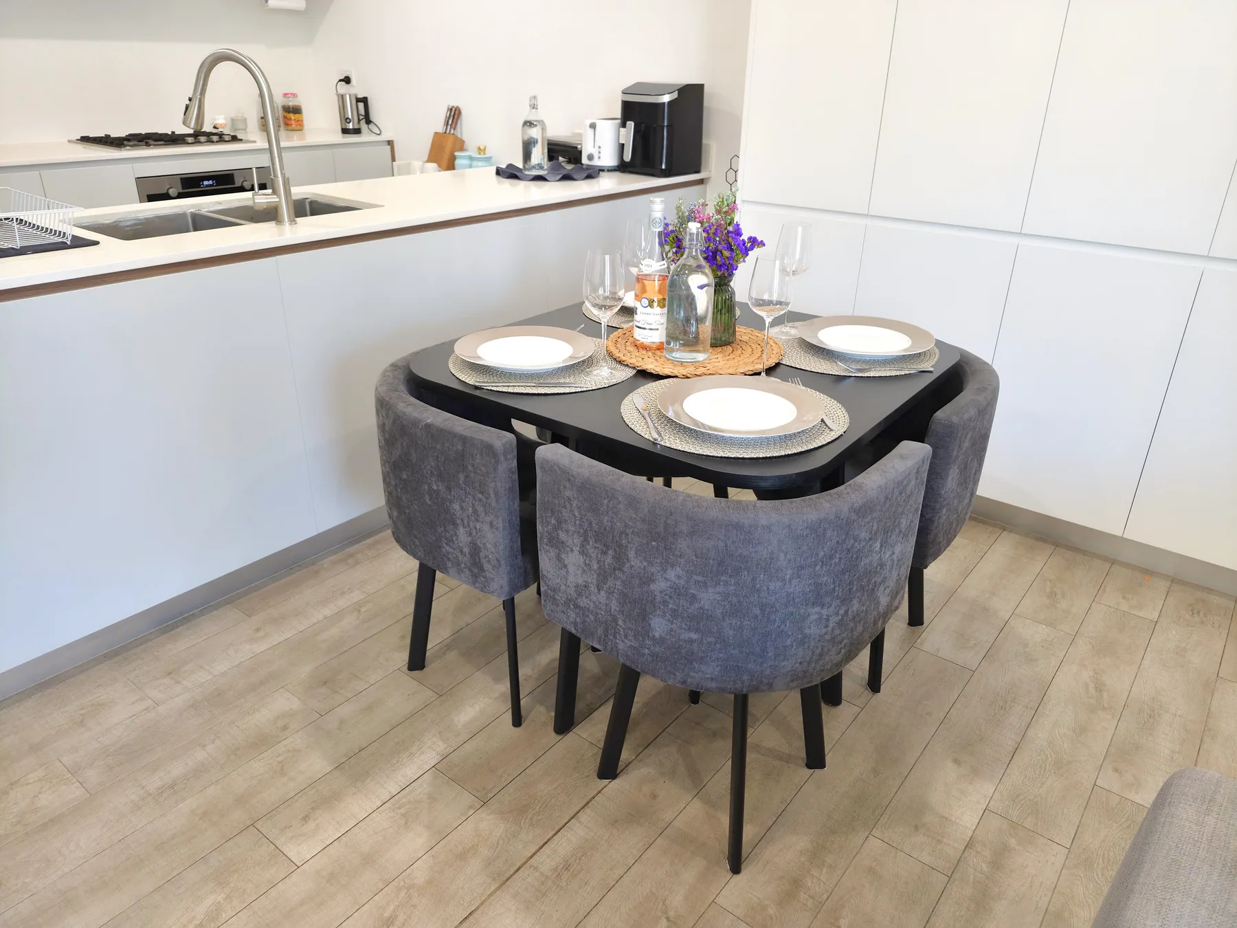 A dining area with a set table beside the kitchen counter.