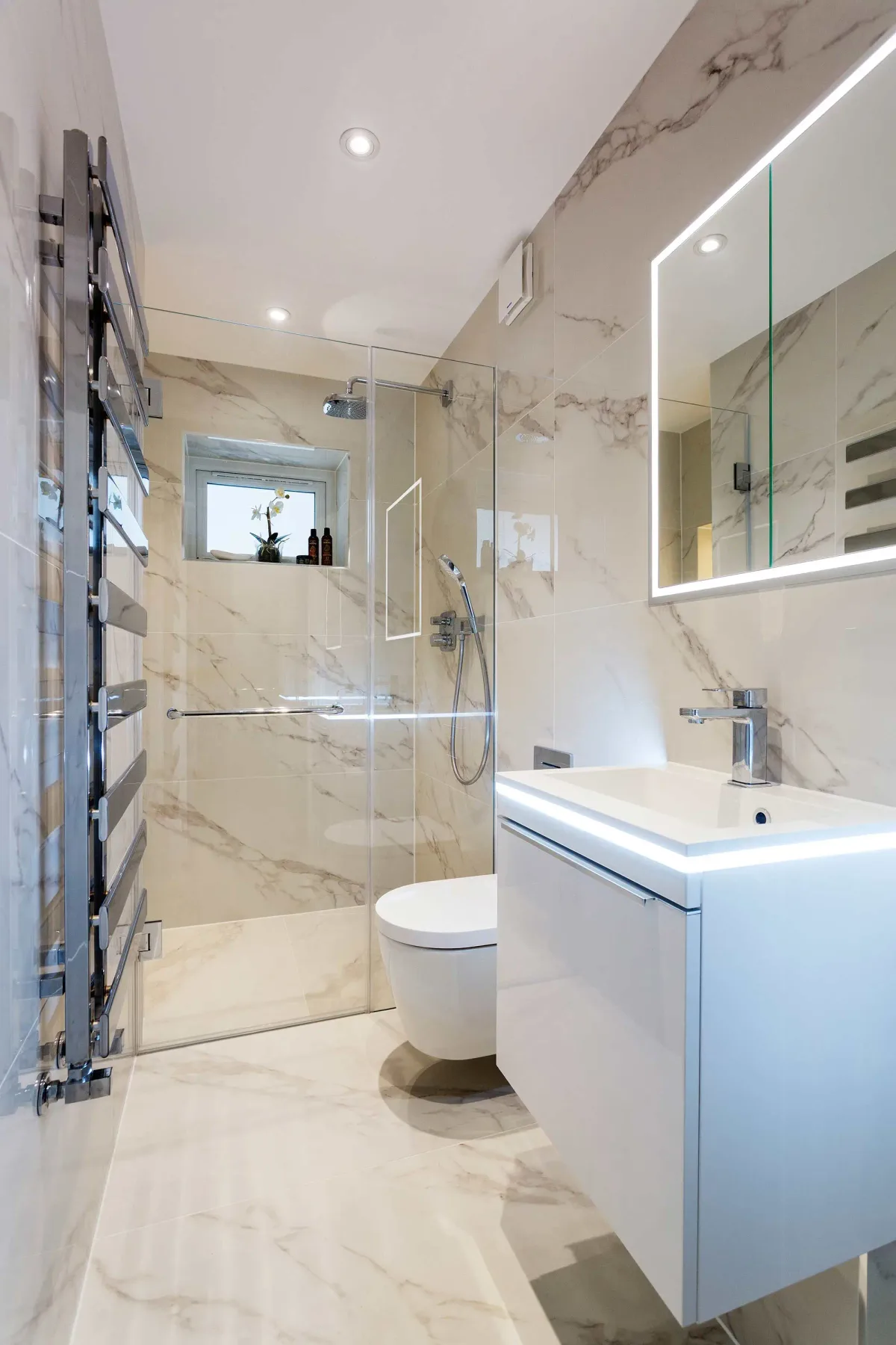 A bright bathroom with a glass shower, toilet, and floating vanity.