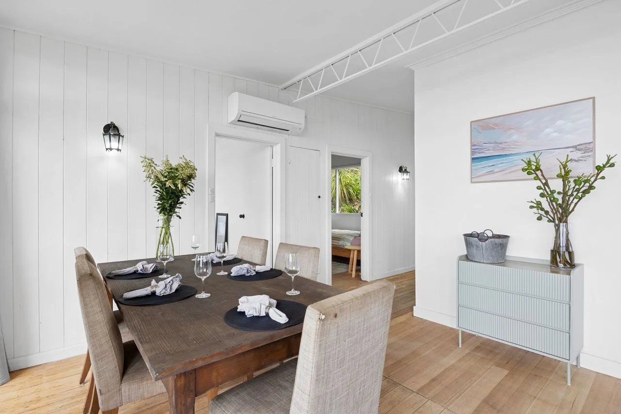 A bright dining room with a wooden table set for a meal.