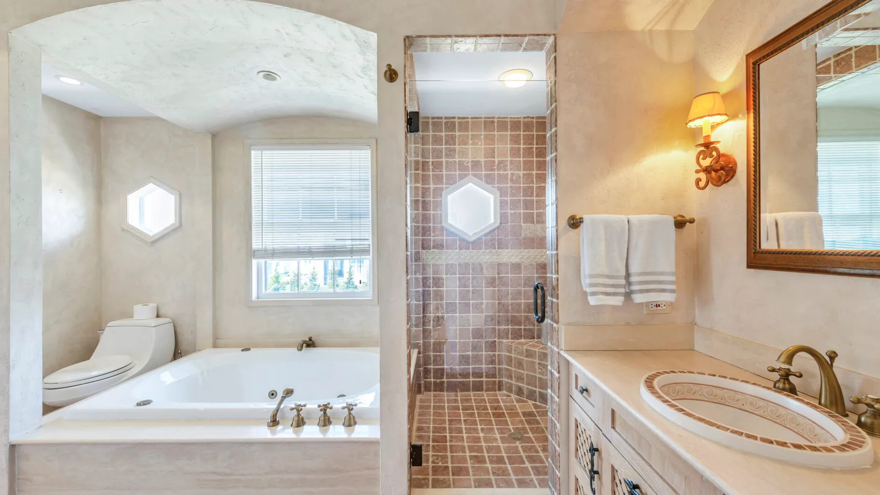 Un baño con bañera, ducha de azulejos y lavabo.