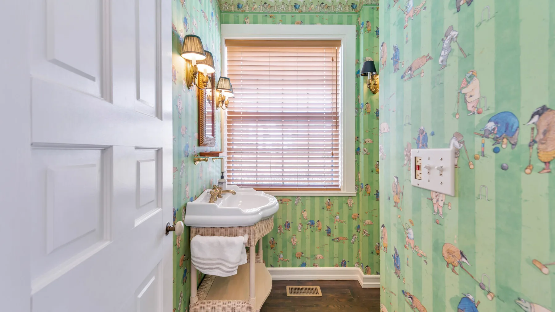 Un baño con lavabo, ventana y decoraciones coloridas en las paredes.