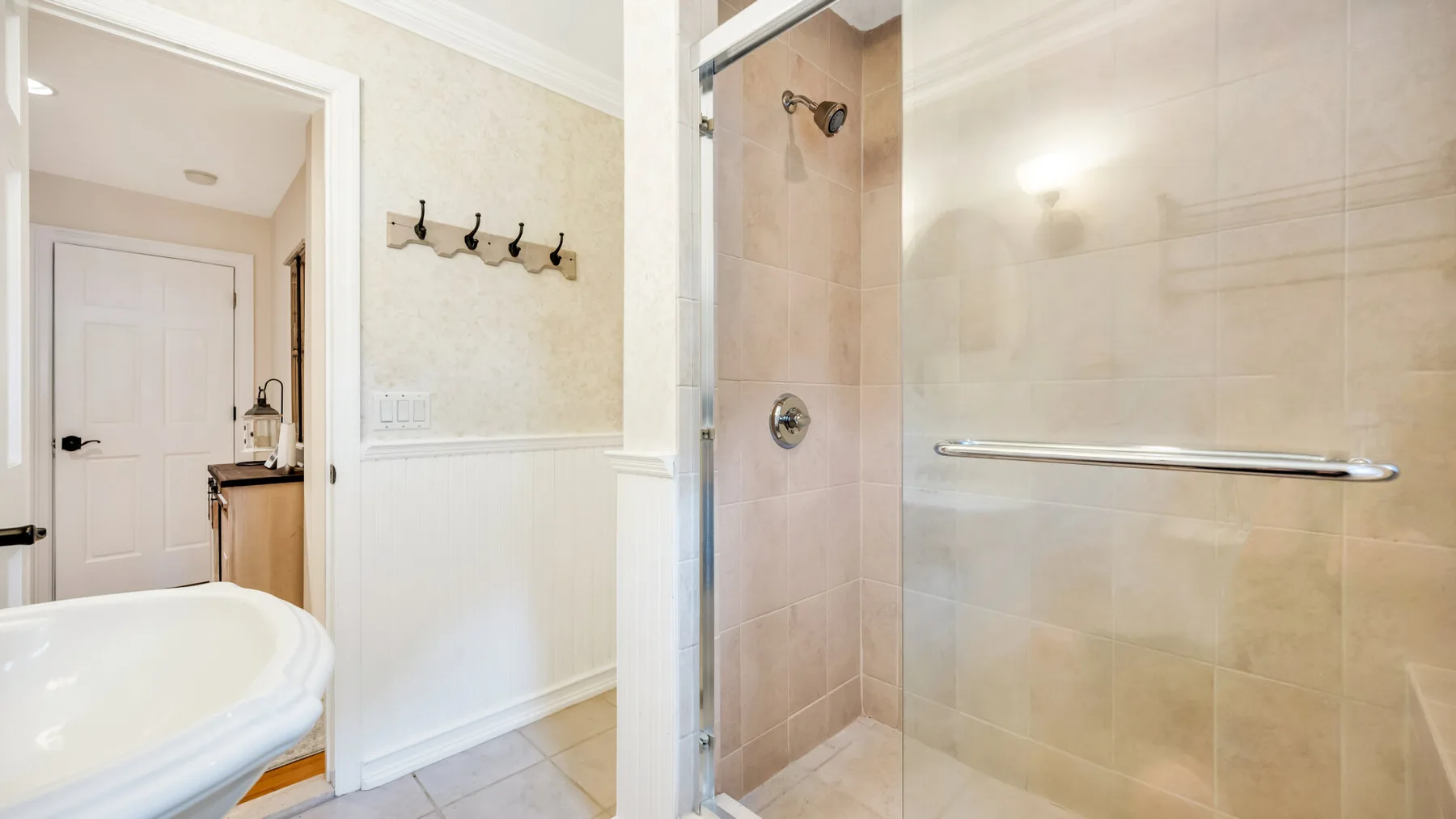Un baño luminoso con bañera y zona de ducha alicatada.