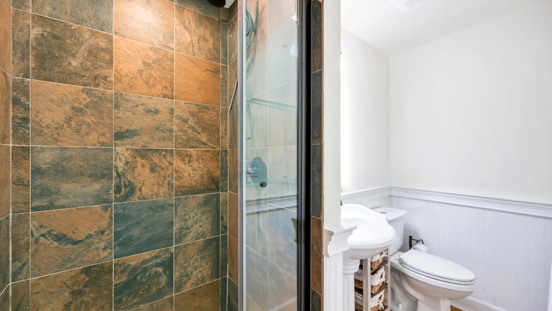 Un baño con una ducha revestida de azulejos y un inodoro.