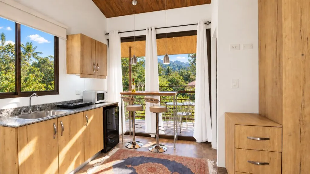 Cocineta y barra de desayuno de la Suite Jardín, con balcón y vistas a las montañas