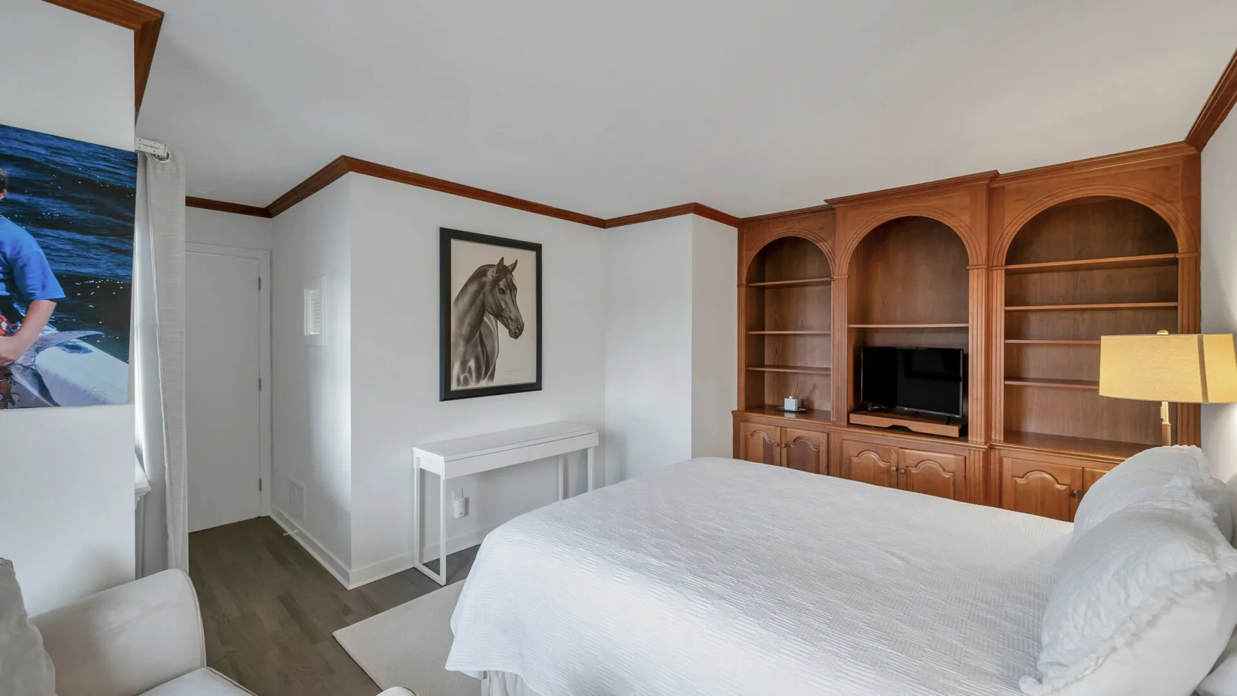 Un dormitorio con una cama grande y estanterías de madera empotradas en la pared.