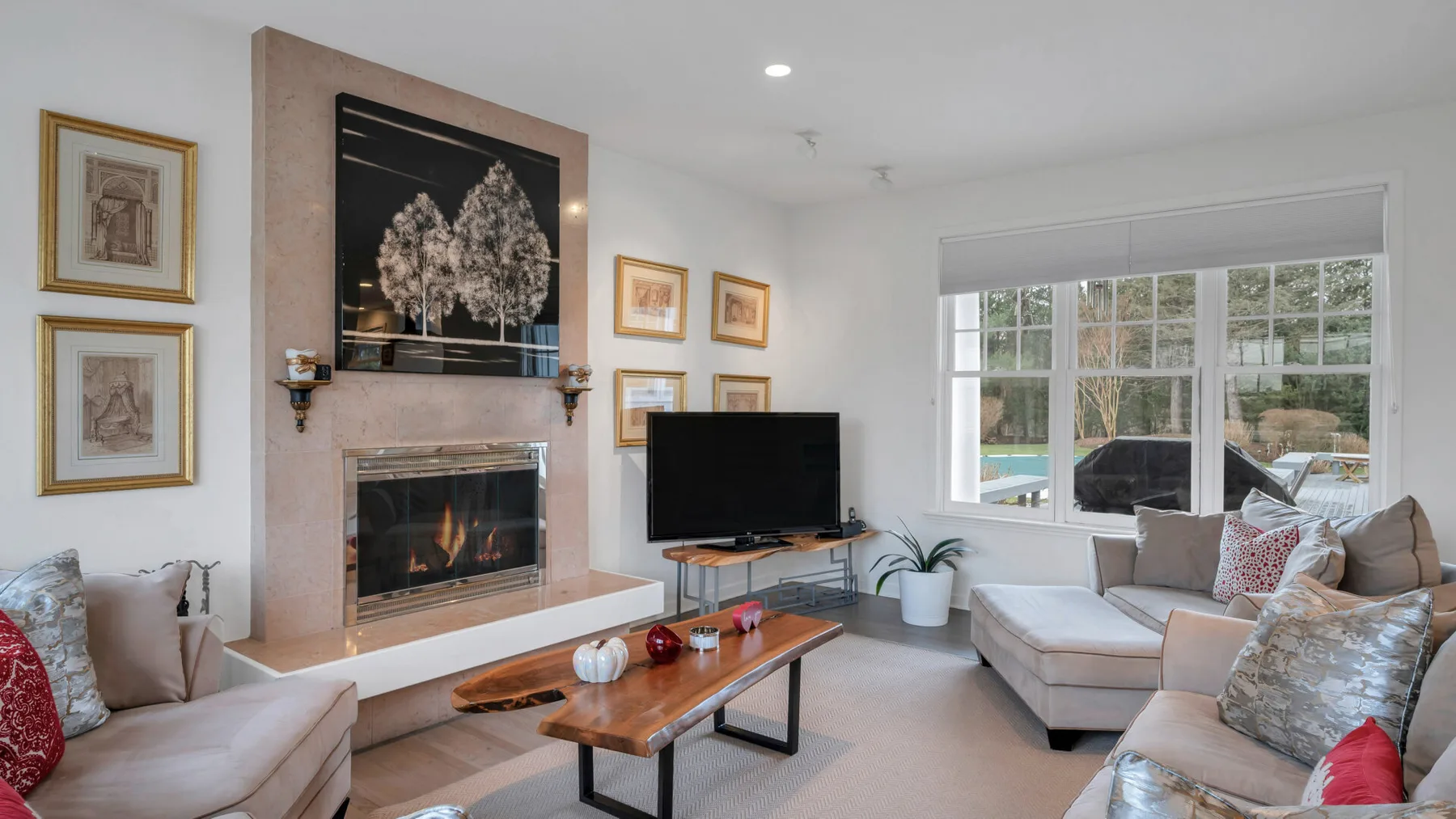 Una sala luminosa con chimenea, asientos y una ventana grande.