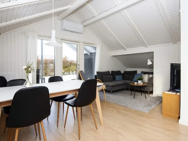 A bright living and dining area with seating arranged around a coffee table.