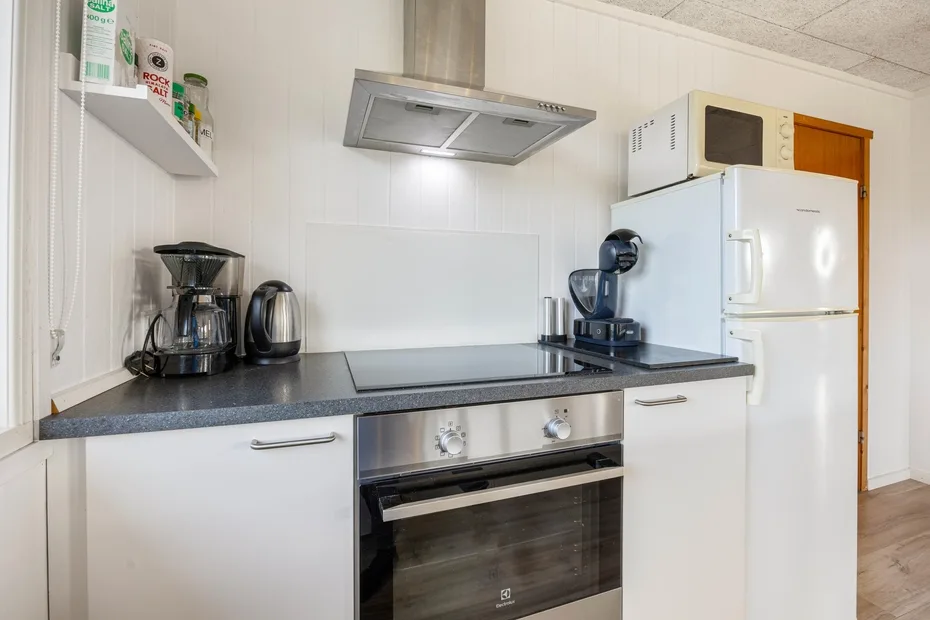 Una cocina luminosa con estufa, horno y refrigerador.